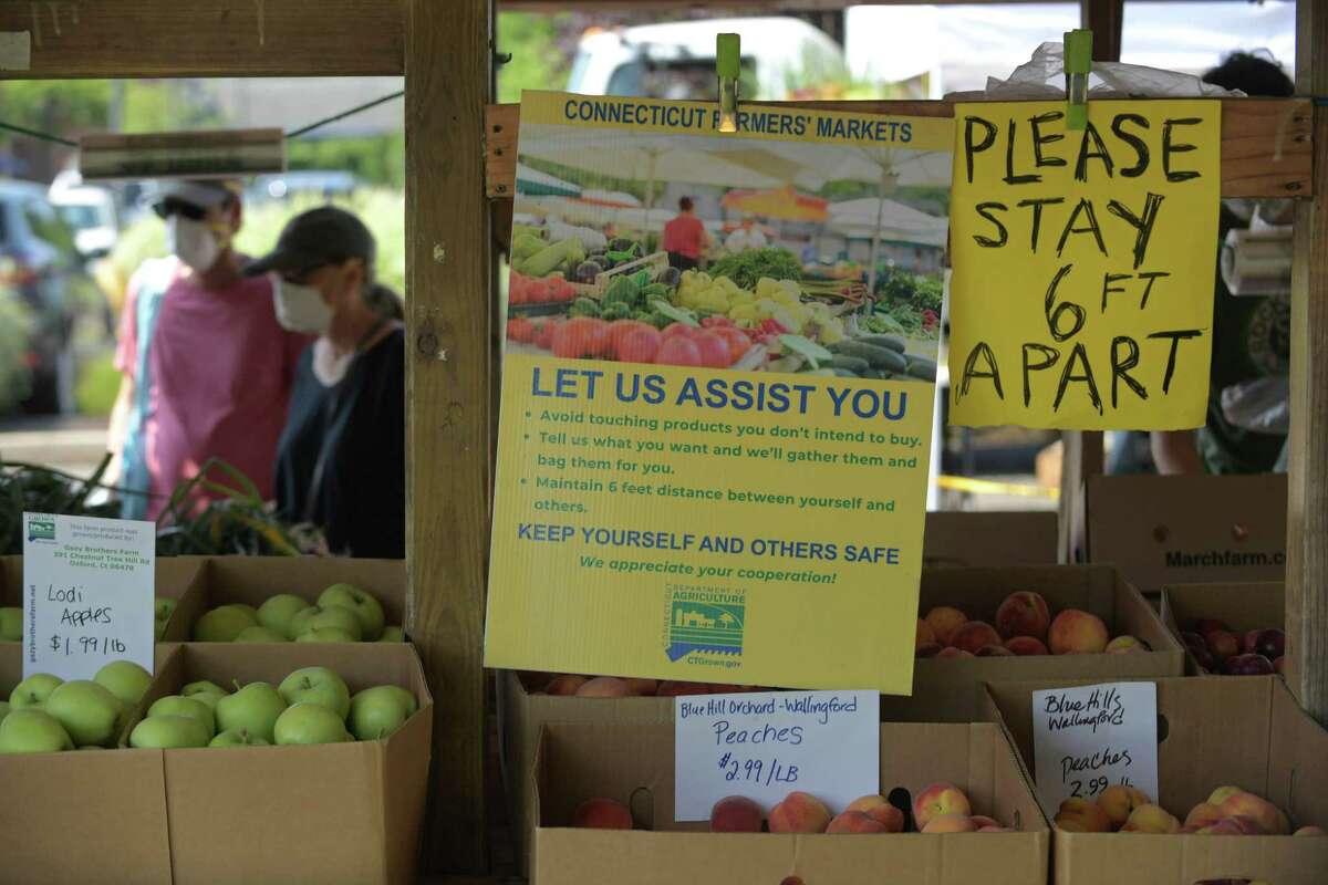 Local residents shop at Gazy Farms stand during the Darien’s Farmers Market Wednesday, July 22, 2020, at The Goodwives Shopping Center in Darien. With many businesses closed during the coronavirus pandemic, farmers markets have been deemed essential businesses by the State of Connecticut.