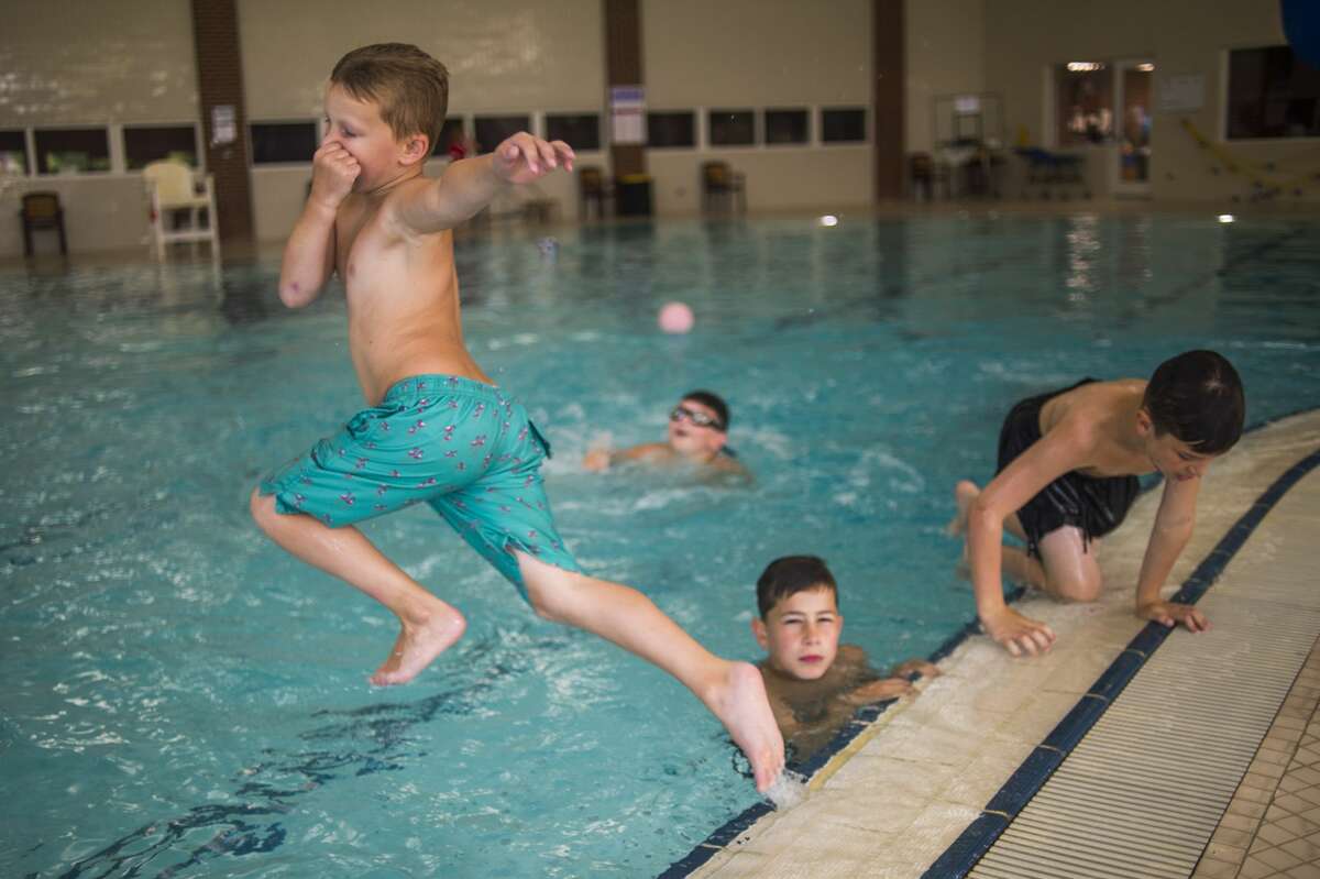 Parker Koch, 7, jumps into the pool during a day camp Wednesday, July 22, 2020 at Greater Midland Community Center. (Katy Kildee/kkildee@mdn.net)
