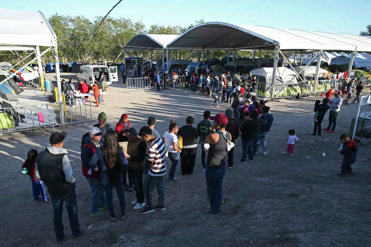 A line forms as Iglesia Puerta del Cielo hands out sweet bread and coffee at a migrant camp by the Gateway International Bridge in Matamoros, Mexico, Thursday, Feb. 6, 2020. The camp started after the U.S. implemented the Migrant Protection Program also known as the Return to Mexico plan. Migrants awaiting their asylum-seeking court date started camping by the sidewalk leading to the bridge. It was recently moved away from the sidewalk on land that was used as soccer fields by the Rio Grande. Currently, the camp is housing around 2,200 migrants.