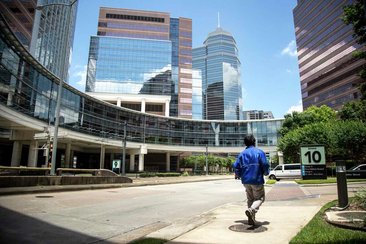 The number of new cases, hospitalizations and deaths from COVID-19 in the Houston area have improved significantly since July, but the pandemic remains a serious threat here. People are pictured moving about the Texas Medical Center.