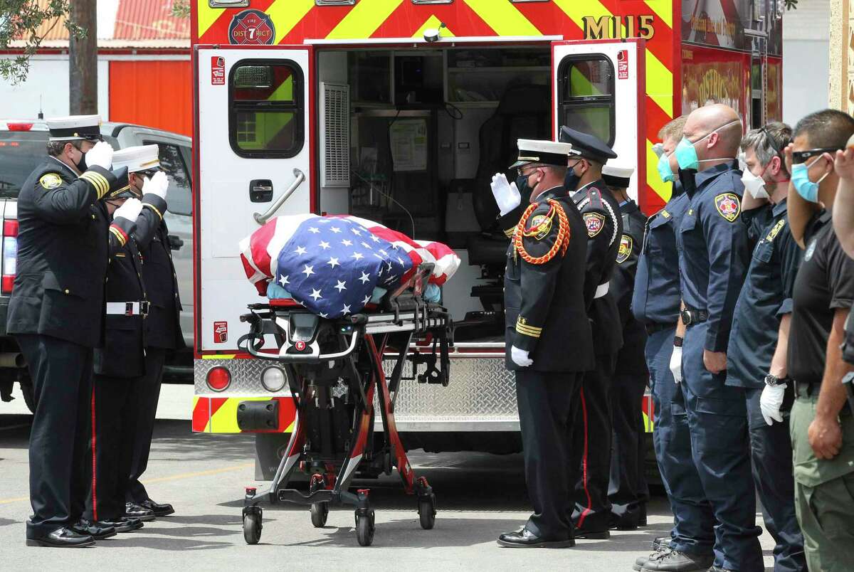 Fire Department honor guard members stand at attebtuib as Bexar County EOC Kyle Coleman flag-draped remains are delivered to the Southside Funeral Home on July 16, 2020. Coleman will be honored at an outdoor funeral service in the Freeman Coliseum parking lot Friday. Family and friends will stay inside their vehicles, listening to the service on an AM radio band. A procession will then make its way to the county line, as Coleman’s remains are taken to Brady, a small town in the heart of Texas about 130 miles northwest of San Antonio, for burial in the family plot.