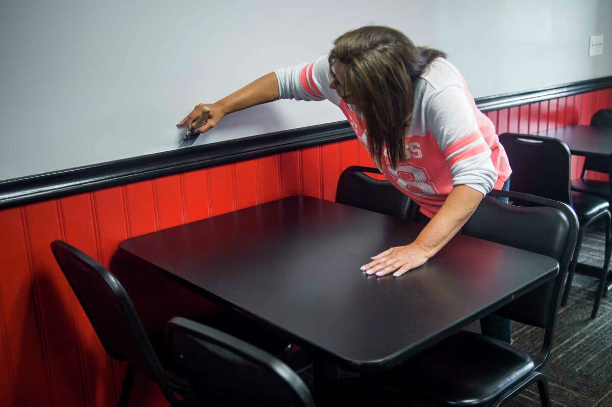 Server Terri Johnson touches up the freshly painted walls inside the new location for Lanny's Restaurant Thursday, July 23, 2020 in Midland. Lanny's has relocated to 4312 N. Saginaw Road, in the building formerly housing Stacker's Grill, with a reopening being planned for mid-August. (Katy Kildee/kkildee@mdn.net)