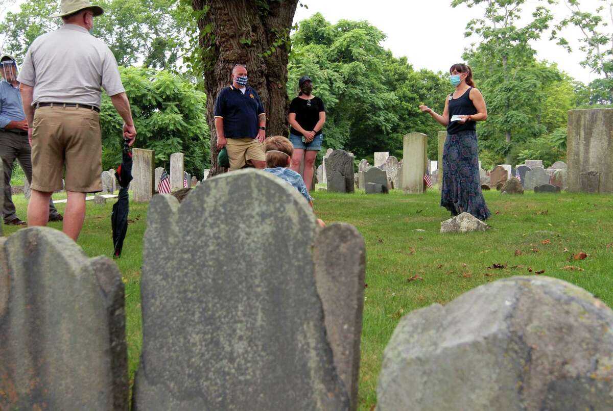 Fairfield Museum's Laurie pasteryak talks to guests about burial customs among Native Americans during Fairfield’s “Old Burying Ground” Walking Tour in Fairfield, Conn., on Wednesday July 22, 2020. Usually the tour is given once a month and on holidays, but this was the first tour given since the outbreak of the coronavirus pandemic.