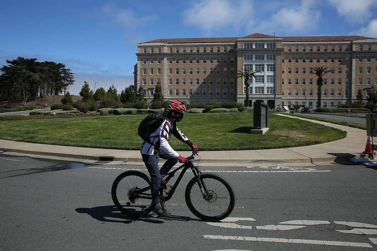 A bicyclist rides past the Landmark Apartments in a slow street zone along Battery Caufield on Wednesday, July 22, 2020 in San Francisco, Calif.