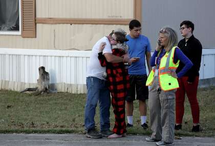Ron Lawrence, left, comforts his daughter, Kallie Lawrence, 11, who knew Kameron Prescott, a 6-year-old boy who was shot by Bexar County Sheriff’s deputies while they were pursuing a suspect in the Pecan Grove mobile home park in Schertz on Dec. 21, 2017.