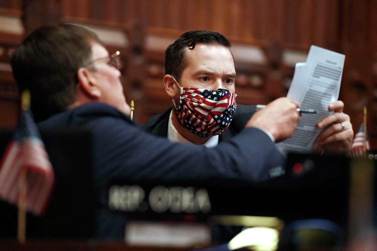 State Rep. Tom O'Dea R-New Canaan, left, hands reads a document with State Rep. Christopher Davis R-Ellington, right, during special session at the State Capitol, Thursday, July 23, 2020, in Hartford, Conn. (AP Photo/Jessica Hill)