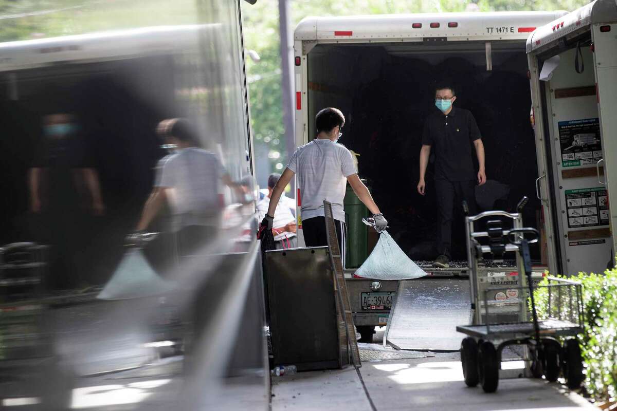 Consulate workers remove items from the Consulate General of China Friday, July 24, 2020, in Houston. U.S.government has ordered the Houston consulate to close by Friday.