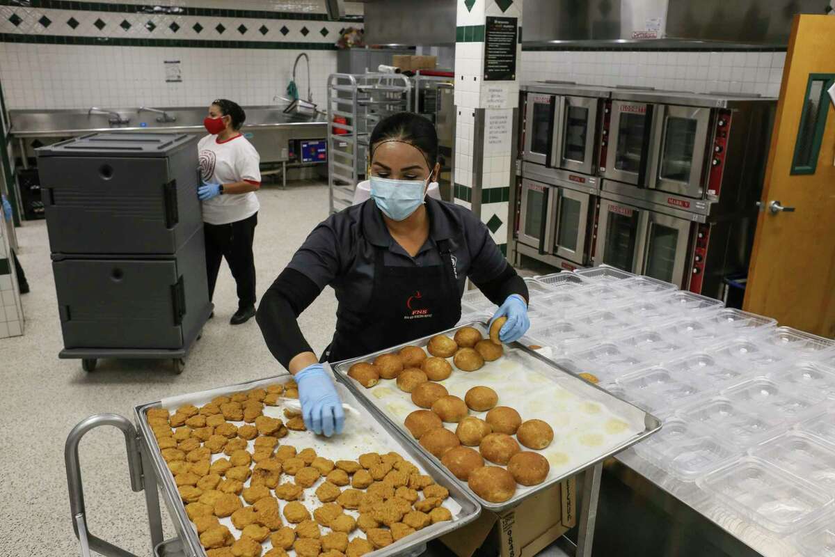 A worker assembles hot lunches for the Brownsville ISD’s summer meal program. School districts across Texas have continued to serve students, yet they’re lossing federal funding.