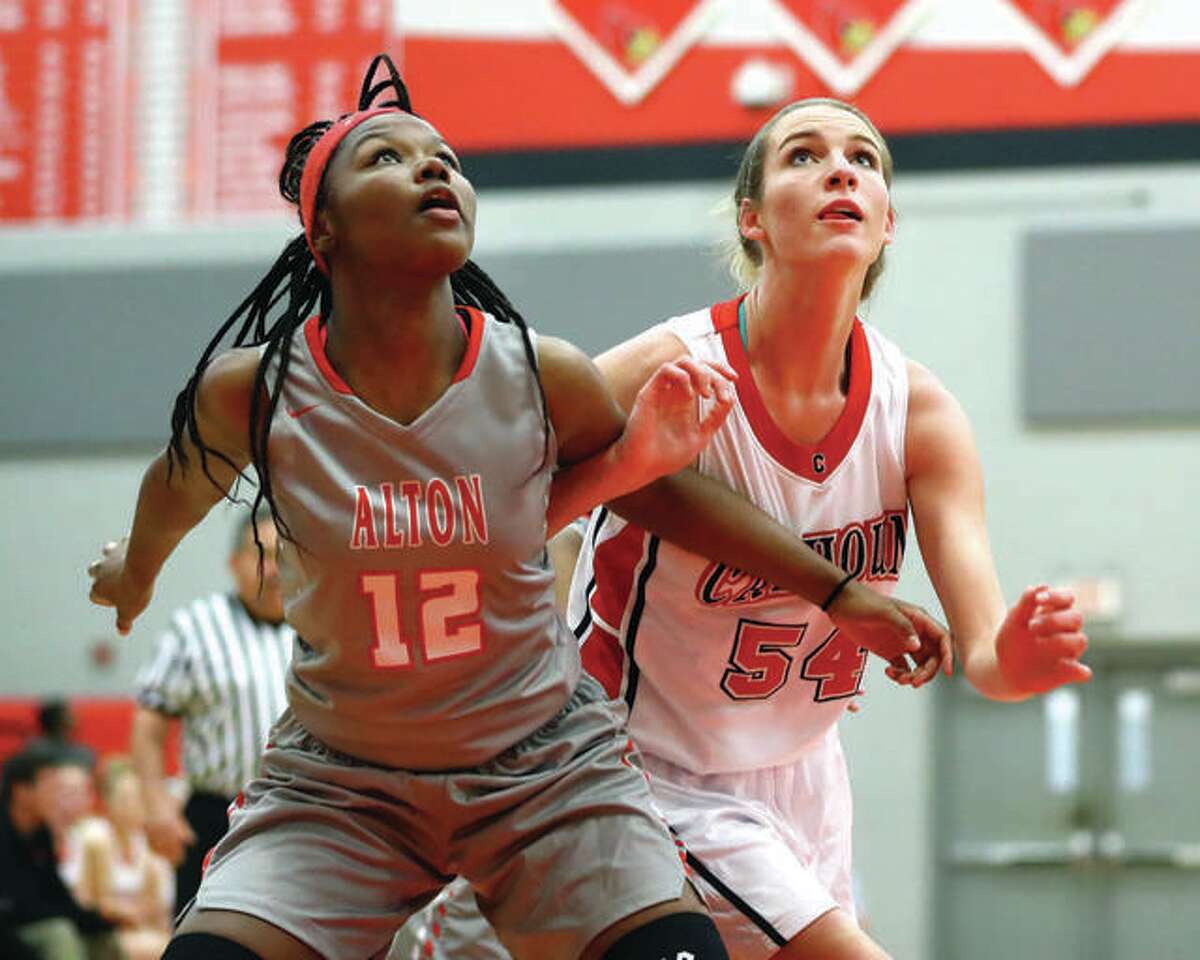 Calhoun’s Grace Baalman (right) works for position against Alton’s Leilani Hill for a rebound during a 2016 game at Alton High. The IHSA is surveying state athletic directors on the possibility of adding a shot clock to girls and boys basketball games.
