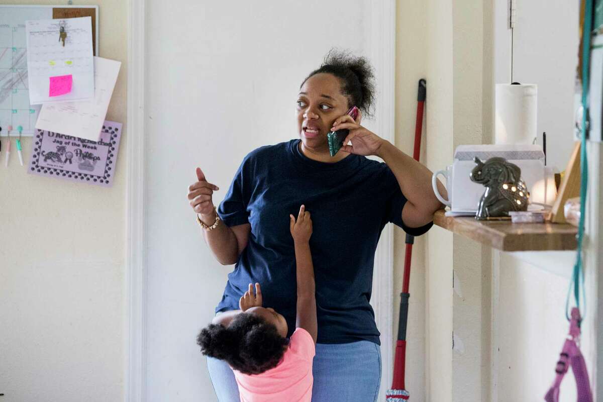 D’Andrea Richardson, 34, who is on unemployment, talks on the phone, as her daughter, D'Aubrei reaches up to be picked up, on Wednesday, July 22, 2020 in Humble. After several months of long hours on the phone with the state unemployment office to apply for and consistently receive unemployment benefits during the COVID-19 pandemic, millions of claimants now face the possibility that their benefits will be dramatically reduced if Congress allows its stimulus program to expire, which provided an additional $600 per week. The last week that claimants will receive the expanded unemployment benefits in Texas is the week ending July 25.