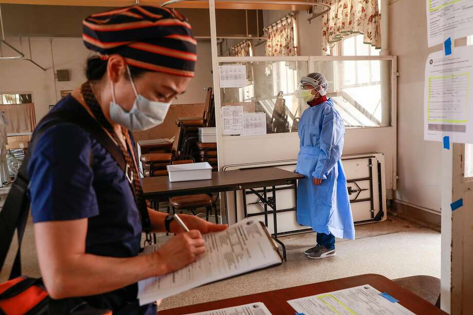 Jolie Wang (left) waits to get tested for the coronavirus by Josephine Ng at Laguna Honda hospital in June. Safety protocols at the hospital have helped avert the tragedy that has befallen other nursing care facilities suffering from coronavirus outbreaks. Photo: Gabrielle Lurie / The Chronicle