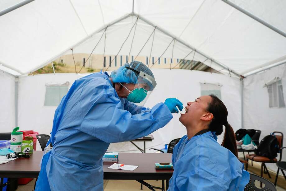 Nurse Rosemary MacLeod (left) performs a coronavirus test on nurse Pauline Tran at Laguna Honda Hospital in June. The nurses are required to get tested every two weeks. Photo: Gabrielle Lurie / The Chronicle