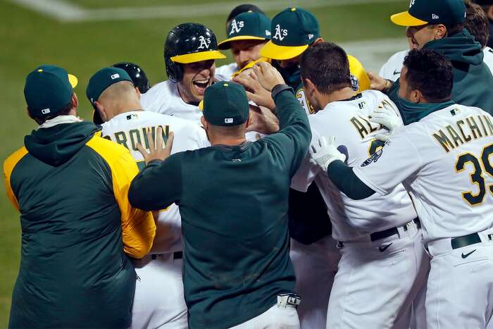 Oakland Athletics' Mike Fiers, center, celebrates with Matt Olson