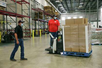 San Antonio Food Bank Warehouse Manager David Carvajal, left, and Victor Mariscal receive the first five pallets of produce from CRE8AD8 under a USDA contract, Thursday, May 28, 2020.