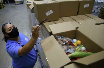 Dayna Robokowski, San Antonio Food Bank Produce Procurement Manager, documents the first boxes of produce delivered by CRE8AD8 under its USDA contract on Thursday, May 28, 2020.