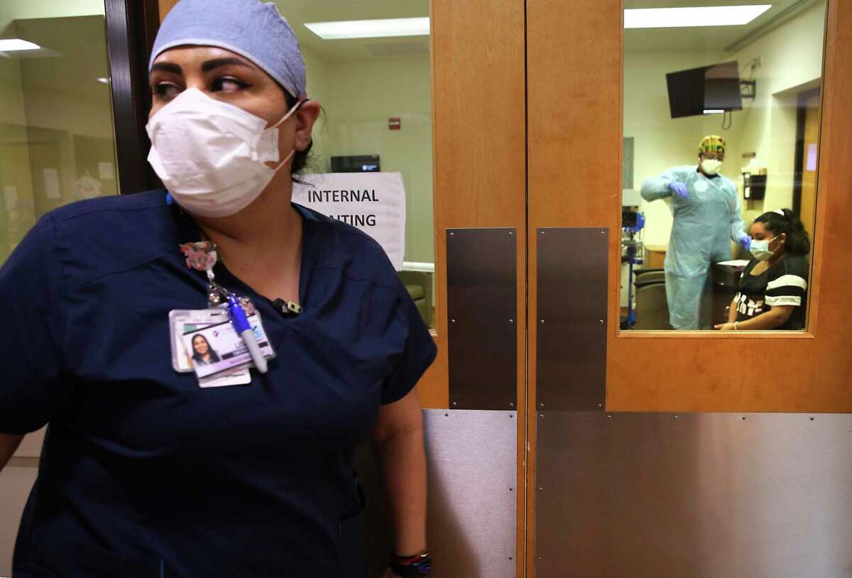 Lisa Torres, left, goes to another patient after assisting a COVID-19 testing in the ER at Christus Santa Rosa Hospital Medical Center, on Tuesday, July, 14, 2020.