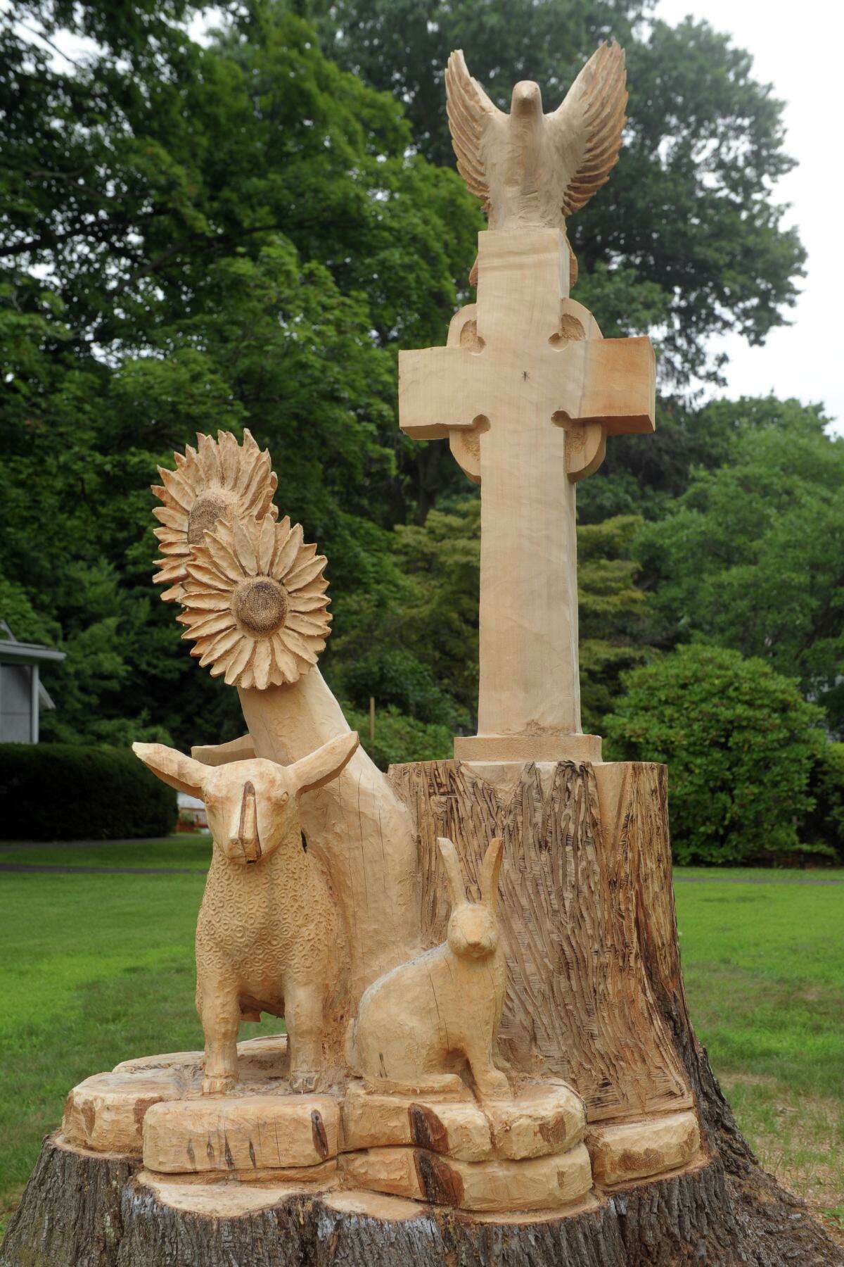 The new sculpture carved out of the truck of an old Maple tree in front Trinity Episcopal Church, in the Nichols neighborhood of Trumbull, Conn. July 24, 2020.