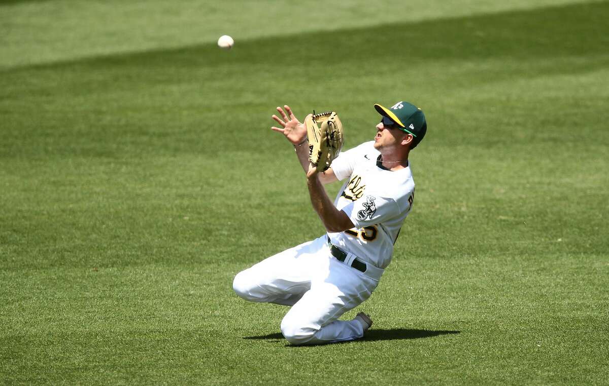 OAKLAND, CALIFORNIA - JULY 25: Stephen Piscotty #25 of the Oakland Athletics catches a ball hit by Mike Trout #27 of the Los Angeles Angels in the fifth inning at Oakland-Alameda County Coliseum on July 25, 2020 in Oakland, California. The 2020 season had been postponed since March due to the COVID-19 pandemic. (Photo by Ezra Shaw/Getty Images)