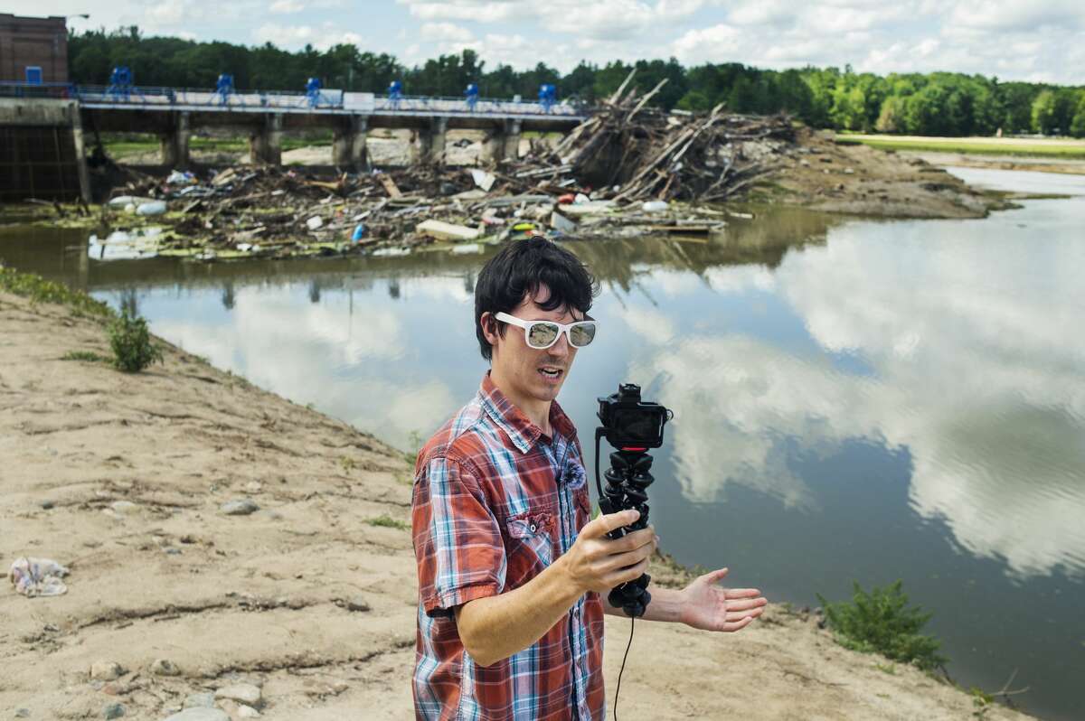 Freeland resident Jordan Mowbray stands in front of the Sanford dam Tuesday, July 21, 2020 as he films an introduction for the newest of his video updates in the aftermath of the flooding in May, which he posts to his YouTube channel. (Katy Kildee/kkildee@mdn.net)