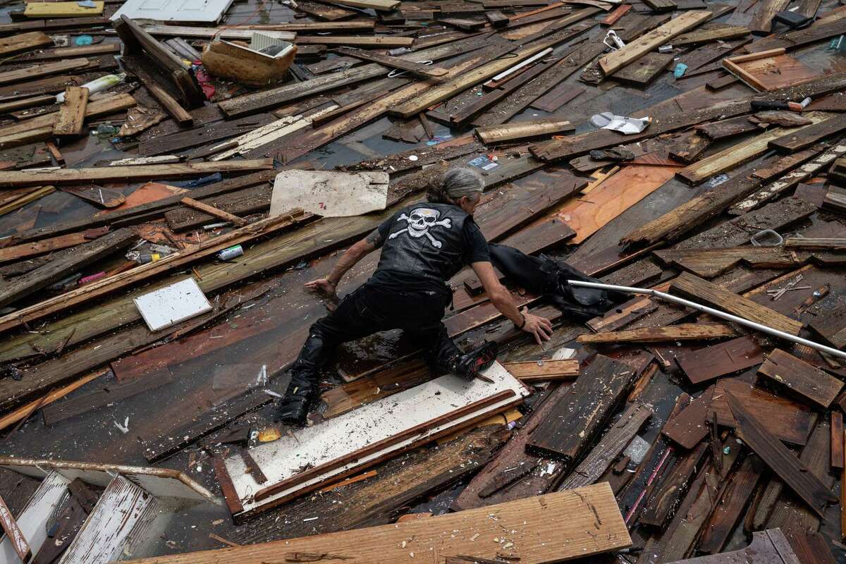 Raymond Maddox searches through the remnants of his houseboat, which was destroyed by Hurricane Hanna, at a private marina in Corpus Christi, Texas, July 26, 2020. (Tamir Kalifa/The New York Times)