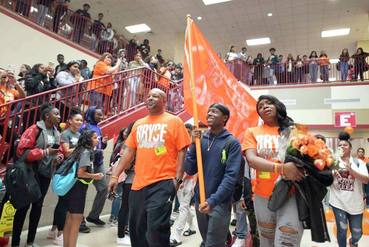 Bryce Wisdom, a Judson High School student athlete, walks with his parents, Rich and Diana Wisdom, during a rally to encourage him on Friday, Oct. 11, 2019. He was leaving school to undergo 25 weeks of chemotherapy at the time.