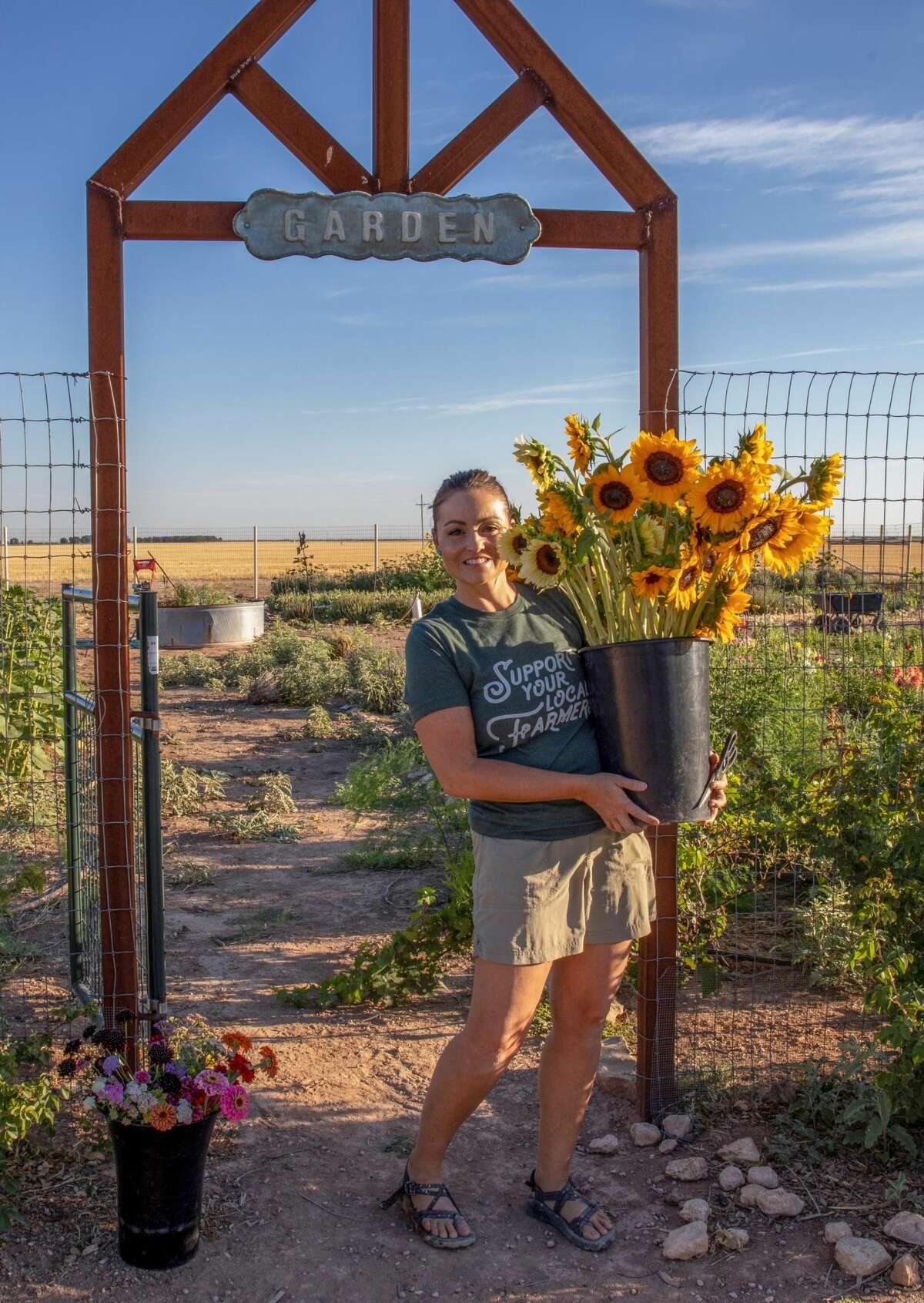 Amanda Evridge cuts flowers June 15 in her garden on her family-owned Evridge Farms near Midkiff.