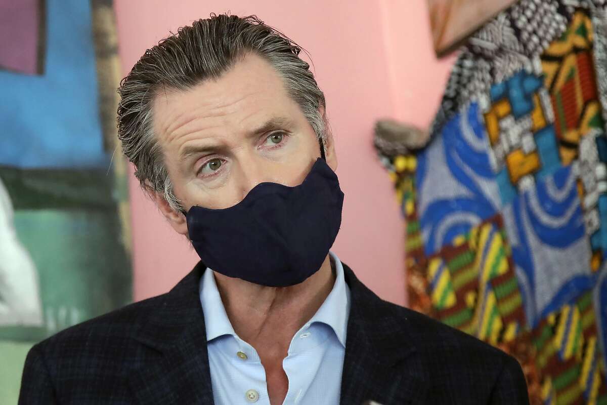 California Gov. Gavin Newsom wears a protective mask on his face while speaking to reporters June 9, 2020, at Miss Ollie's restaurant in Oakland, Calif. Newsom's office drew criticism for a tweet advising people to keep their mask on between bites when dining out.