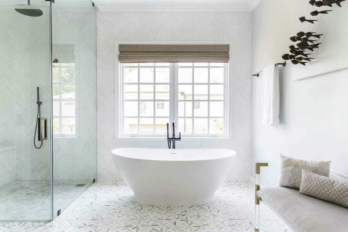 For this spa bathroom in Houston, Oakland-based interior designer Kelly Finley positioned a freestanding soaking tub atop a patterned tile floor and beside a walk-in shower.
