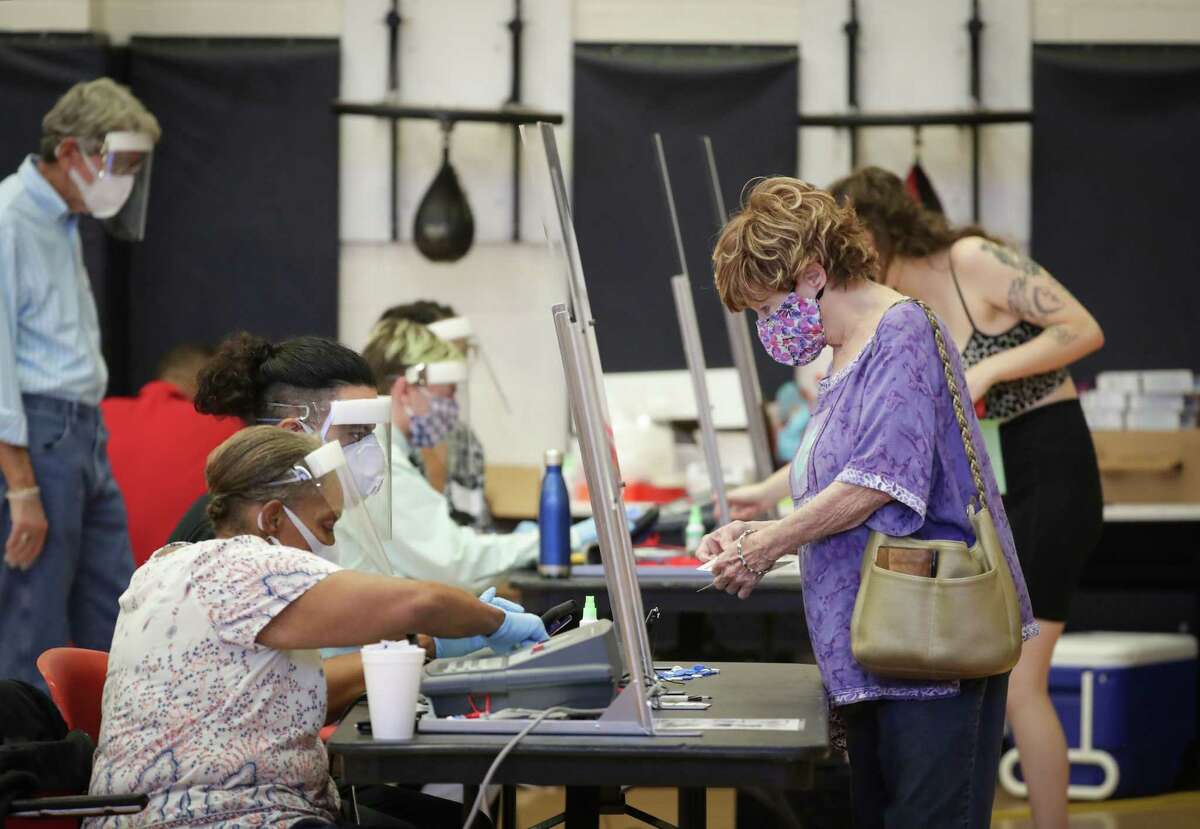 Voters check in before voting at the Metropolitan Multi-Services Center, 1475 West Gray St., Tuesday, July 14, 2020, in Houston.