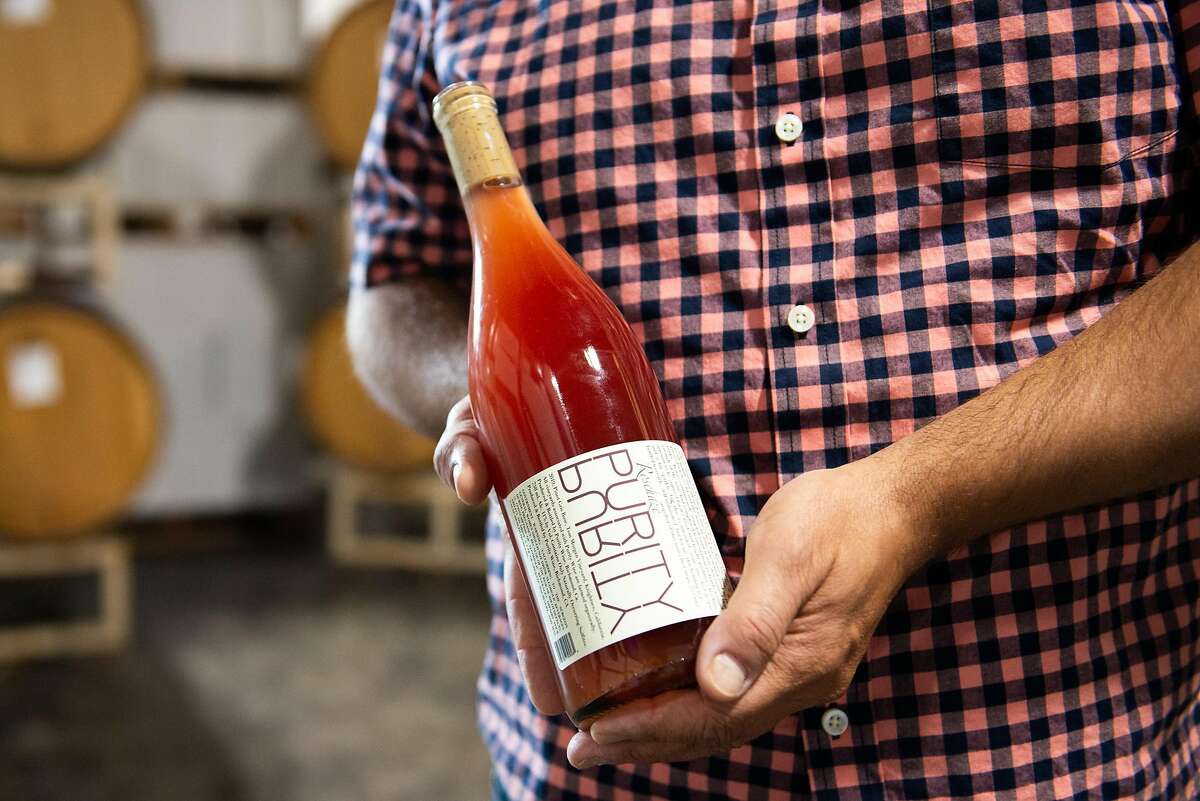 Noel Diaz, wine maker of Purity Wines, holding a bottle of wine in his tasting room on July 24, 2020 in Richmond, Calif.