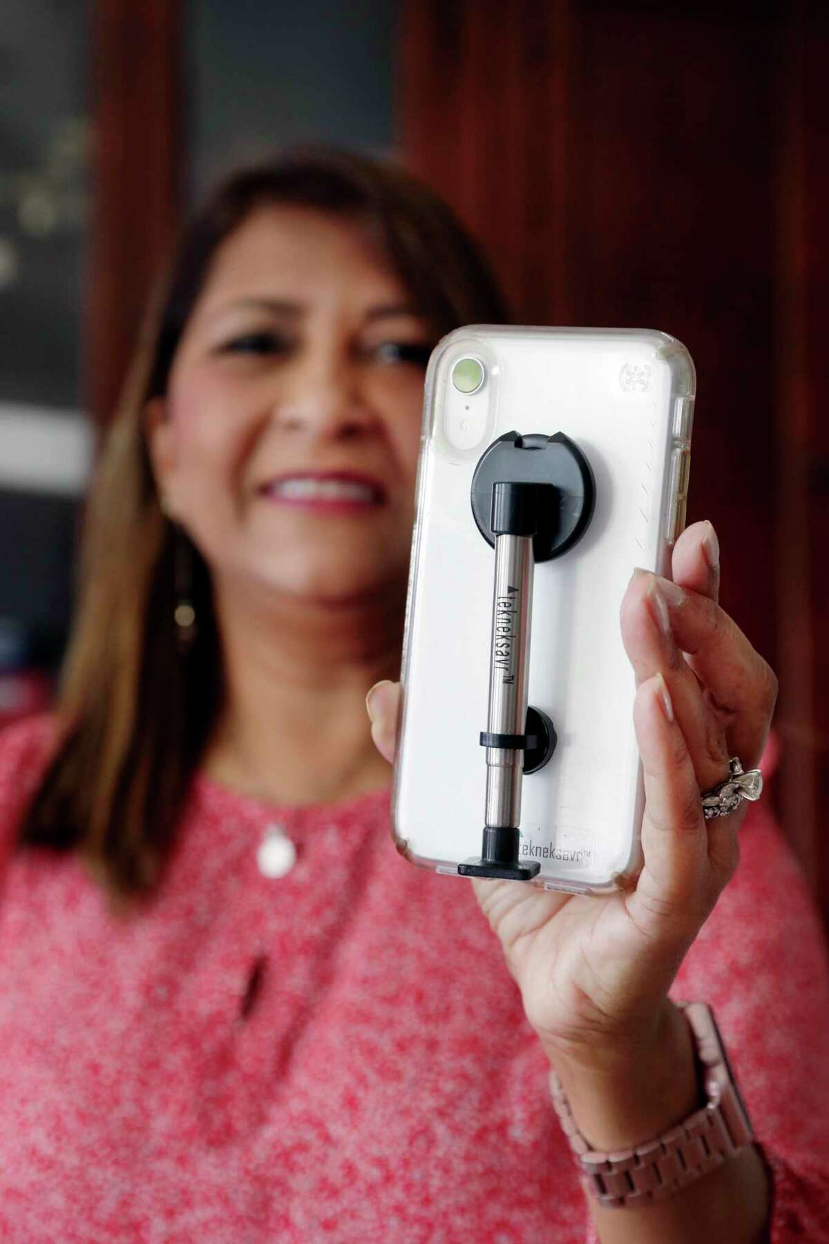 Atiya Syverson, a workplace ergonomics consultant, with her smart phone adapter invention, the “Tekneksavr”, to help relieve “text neck” Tuesday, Jul. 14, 2020 at her home in Katy, TX. The multi-use phone attachment improves posture and neck pain while using a smart phone.
