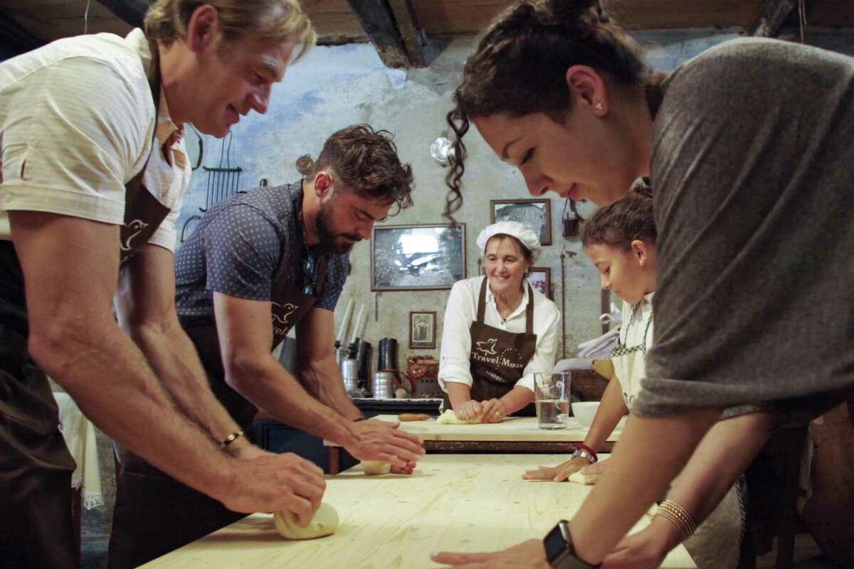 Darin Olien, a la izquierda, con masa de cacao Zac Efron, otro a la izquierda mientras aprenden a hacer pan y pasta en Cerdeña, Italia, conocida por sus grandes residentes mayores de 100 años.