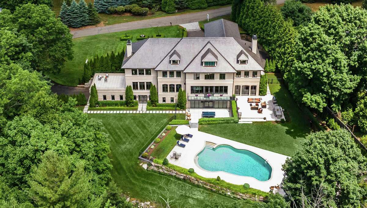 The landscaping and mature trees combine to create a private setting close to town and all its amenities. There is a house within the town's borders that also fits that description. It probably took a left- and right-brained-thinking architect to design the masterpiece that is the tan-colored custom-built concrete, stucco and stone modern colonial house at 8 Brookside Drive, located on a quiet cul-de-sac. It has a logical flow from room to room in its contemporary, open floor plan and it exhibits creative, attractive spaces custom designed for luxurious living and entertaining. It's on the market for $5,250,000.