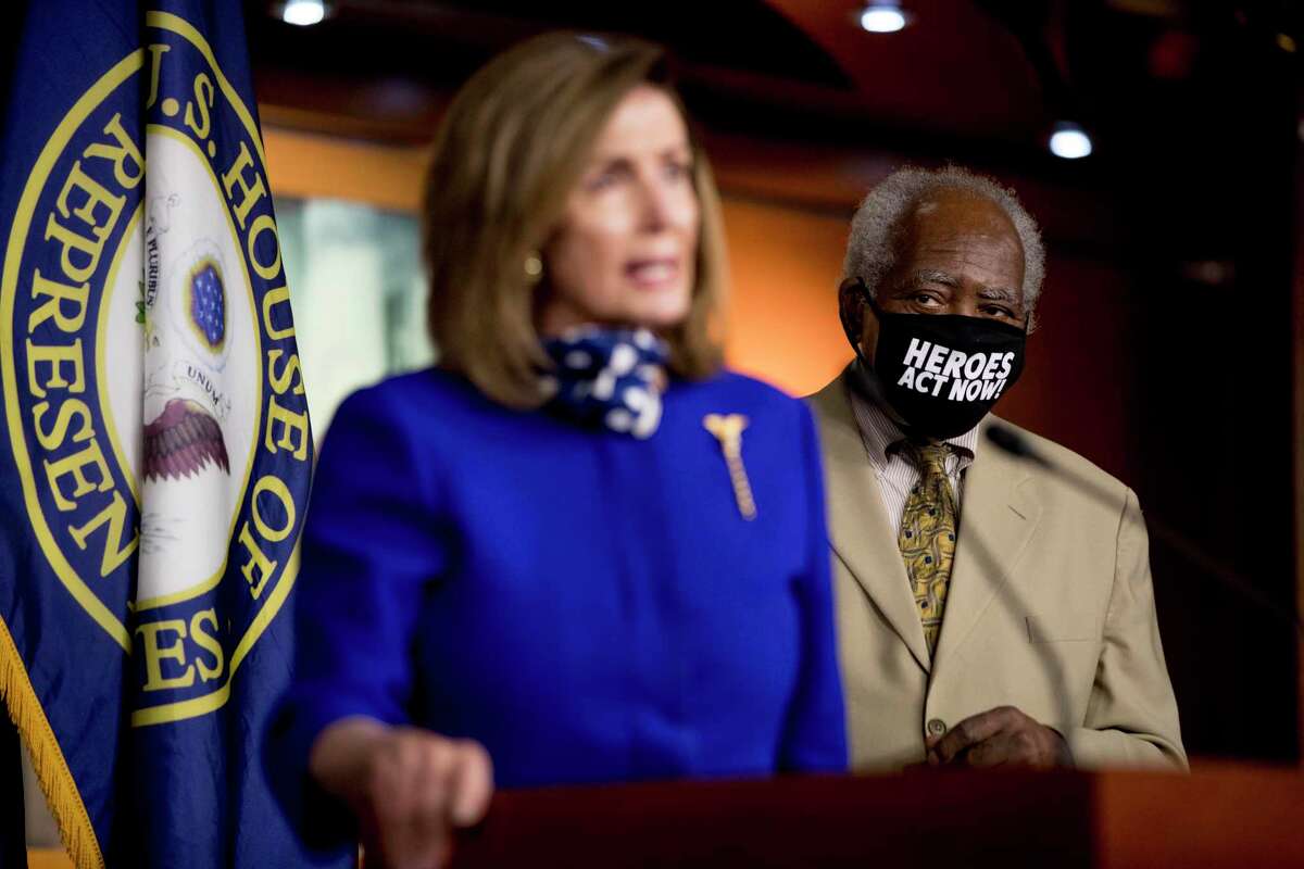 Rep. Danny Davis, D-Ill., right, wears a mask that reads "Heroes Act Now" as House Speaker Nancy Pelosi of Calif., left, speaks during a news conference on Capitol Hill in Washington, Friday, July 24, 2020, on the extension of federal unemployment benefits.
