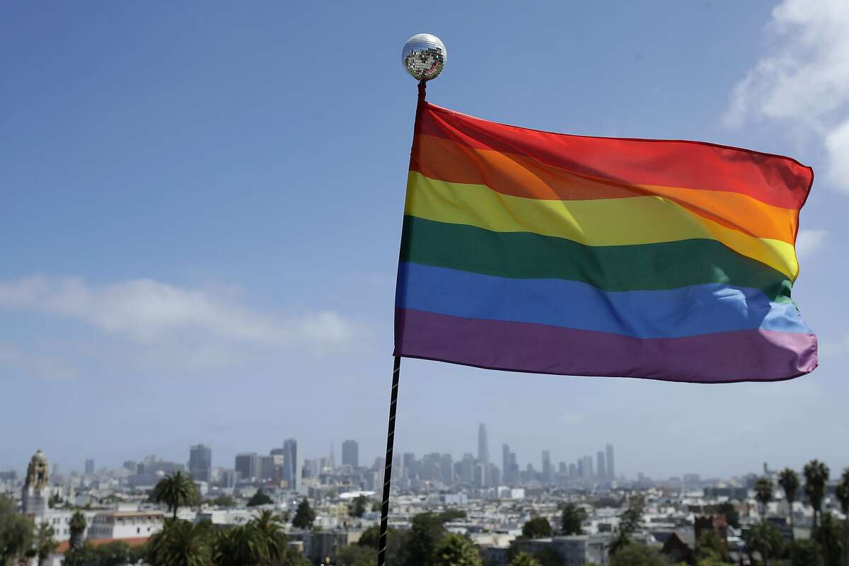 A rainbow flag set up by Ronnie Alvarez, lead designer of Balloon Magic, flies over the skyline at Dolores Park in San Francisco, Sunday, June 28, 2020. (AP Photo/Jeff Chiu)