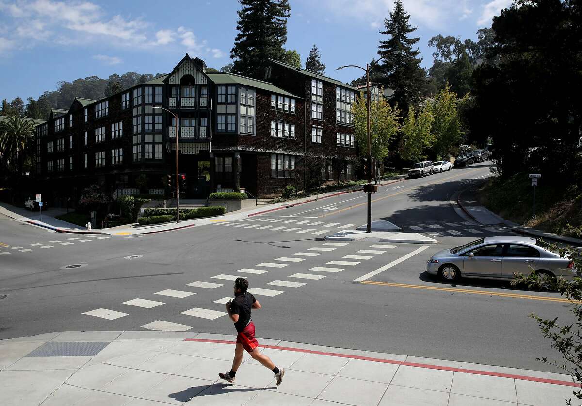 A runner passes a student housing building at UC Berkeley at the intersection of Hearst and Gayley on Tuesday, July 28, 2020, in Berkeley, Calif. Many Bay Area universities are still planning to offer on-campus housing to some of the student population in the fall, even though classes will be almost entirely online. But the residential experience is bound to be unlike any other year--UC Berkeley, for instance, plans to have students self-isolate upon arrival on campus and then remain in small social bubbles after. The revised housing plans come as cases spike in California, making the school year more uncertain.