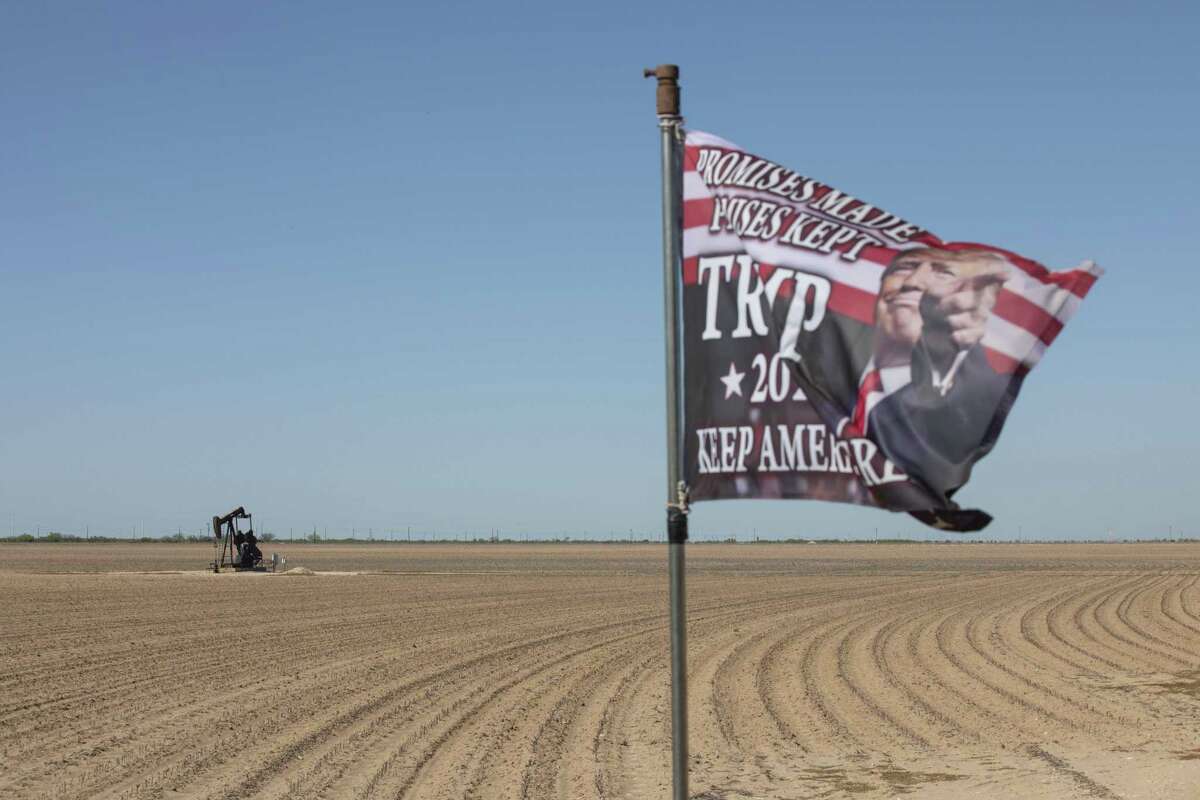 An active pump jack stands past a Trump 2020 flag flying at a private ranch in Midland, Texas, U.S, on Thursday, April 23, 2020. President Trump plans to visit the heart of Texas oil country on Wednesday.