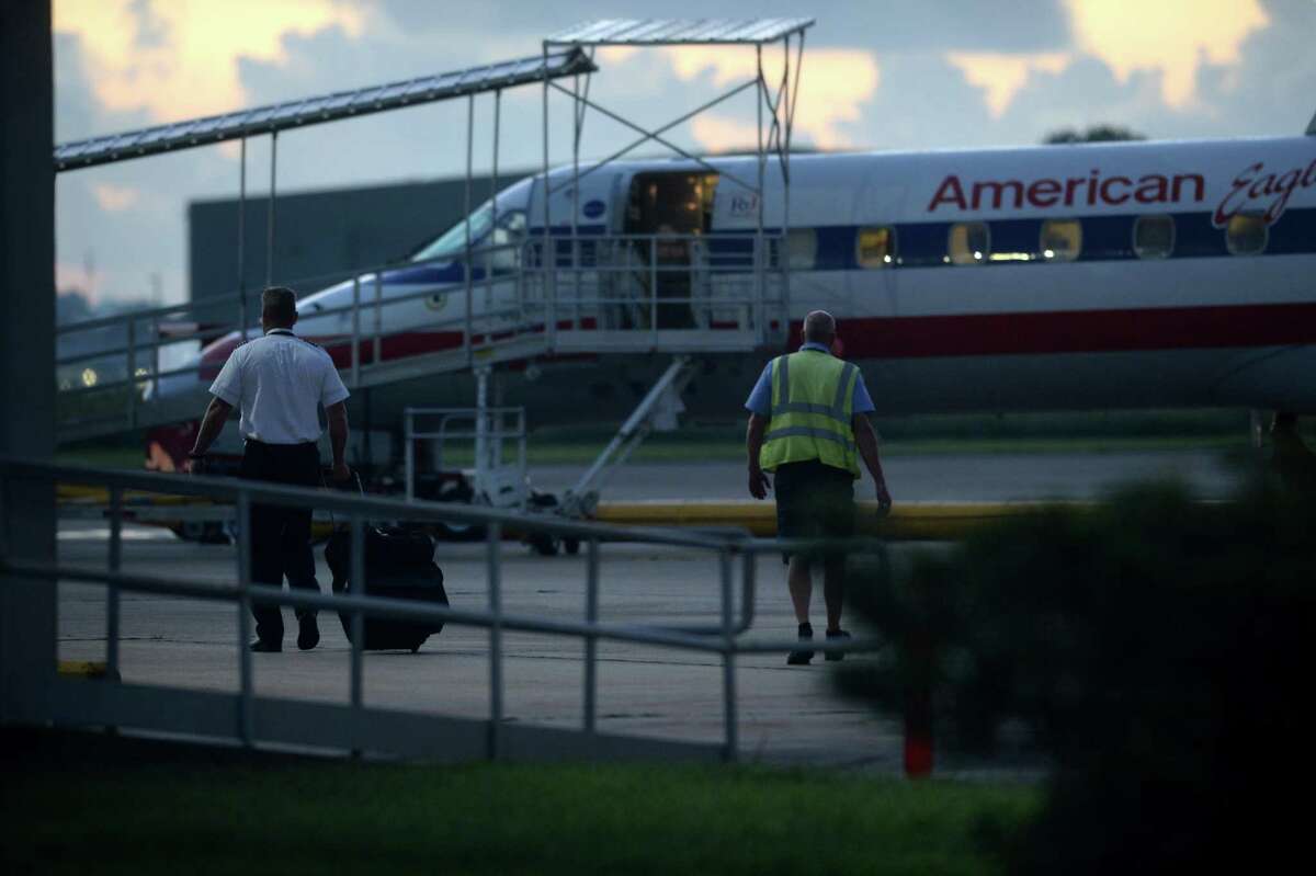 A crew member walks toward an American Airlines plane at the Jack Brooks Regional Airport early Thursday morning. In recent weeks, several passengers were bumped from their flight due to the weight limitations of using the airport?•s shorter, secondary runway. Construction on the primary runway was finished Tuesday and regular traffic is expected to continue. Photo taken Thursday, September 22, 2016 Guiseppe Barranco/The Enterprise