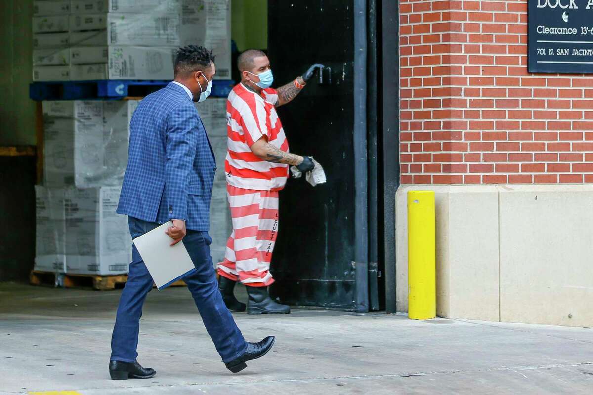 Harris County Jail inmates wear masks as they clean a loading dock, Friday, April 3, 2020, at the Harris County Jail in downtown Houston.