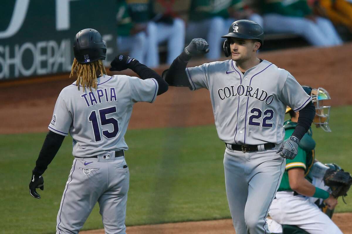 OAKLAND, CALIFORNIA - JULY 28: Sam Hilliard #22 of the Colorado Rockies celebrates with Raimel Tapia #15 after hitting a two-run home run in the top of the fourth inning against the Oakland Athletics at Oakland-Alameda County Coliseum on July 28, 2020 in Oakland, California. (Photo by Lachlan Cunningham/Getty Images)