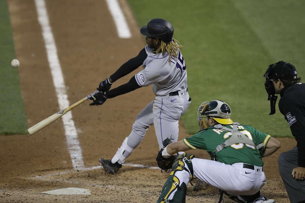 Colorado Rockies' Raimel Tapia swings for an RBI sacrifice fly against the Oakland Athletics in the fifth inning of a baseball game Tuesday, July 28, 2020, in Oakland, Calif. (AP Photo/Ben Margot)
