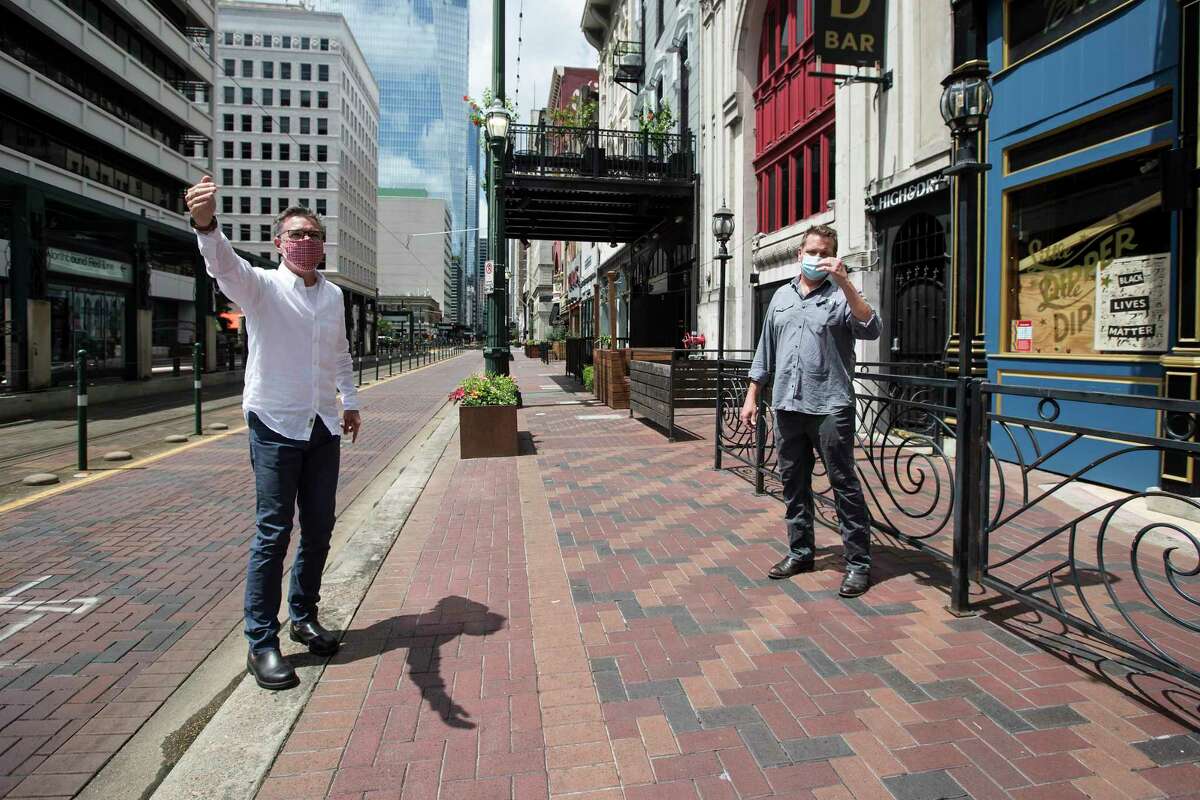Kinder Baumgardner, managing principal SWA, left, and Scott Repass, owner the Little Dipper, walk down Main Street as they talk about a proposal on July 27, 2020, to close the road to vehicular traffic in downtown Houston, so bars and restaurants can use the street to serve customers at a safe distance.