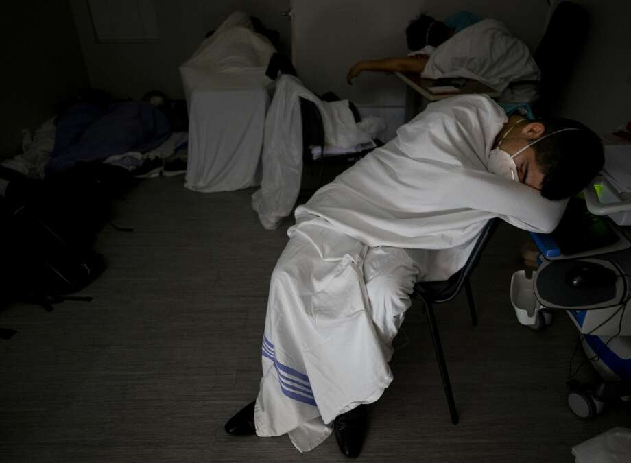 After working roughly 20 hours, medical interns sleep in the intern room inside the COVID-19 intensive care unit at UMMC on June 29, 2020. They slept intermittently for about three hours. Photo: Godofredo A. Vásquez/Staff Photographer / ? 2020 Houston Chronicle