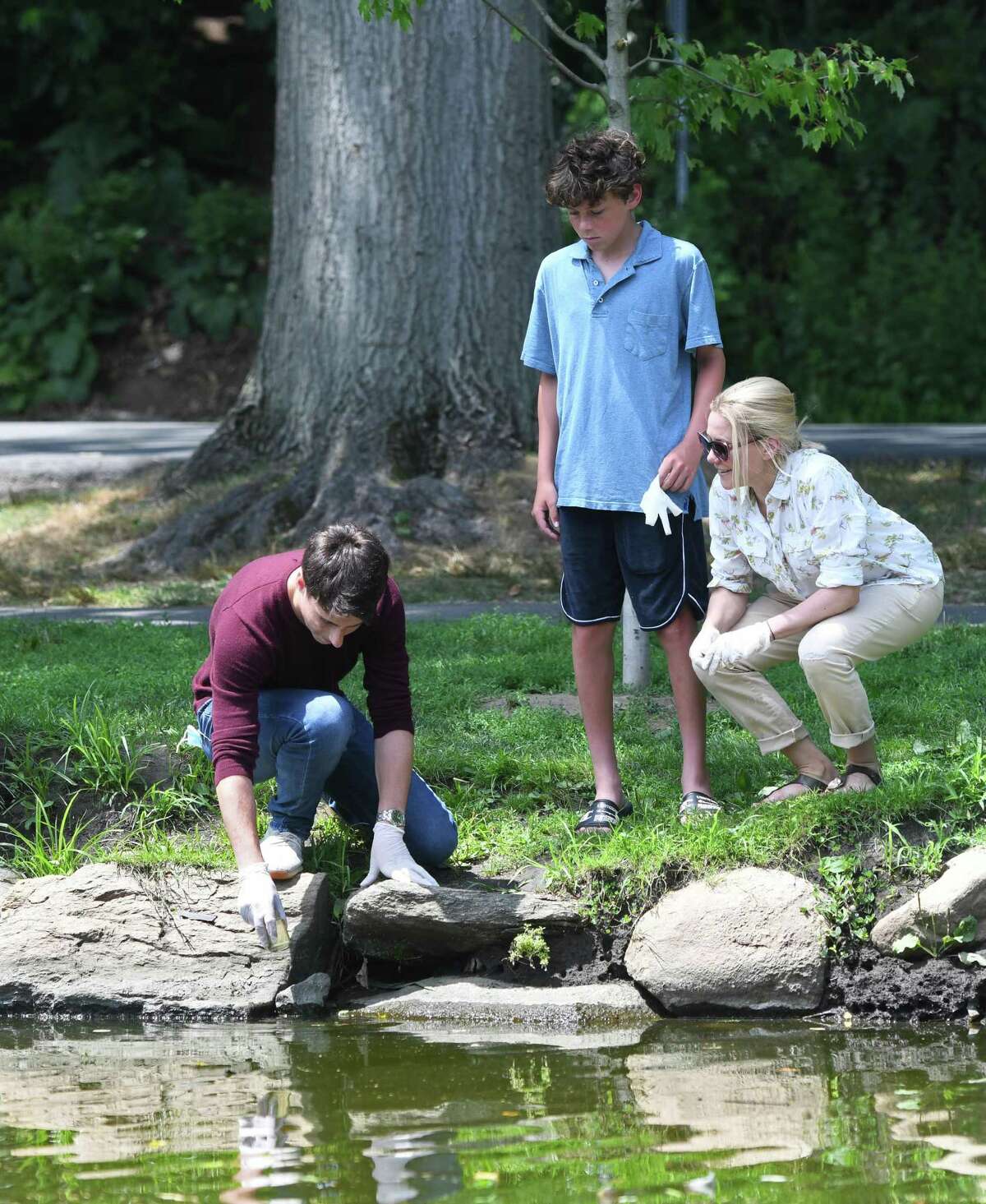 Greenwich's Jack Linardos, 17, left, collects a sample for a water test with Riverside's Luke Martinez, 15, and Dr. Caroline Martinez at Binney Park in Old Greenwich, Conn. Sunday, July 26, 2020. Dr. Martinez has discovered potentially dangerous algae blooms in local waters, something she said could present a threat to shellfish and to people and pets.