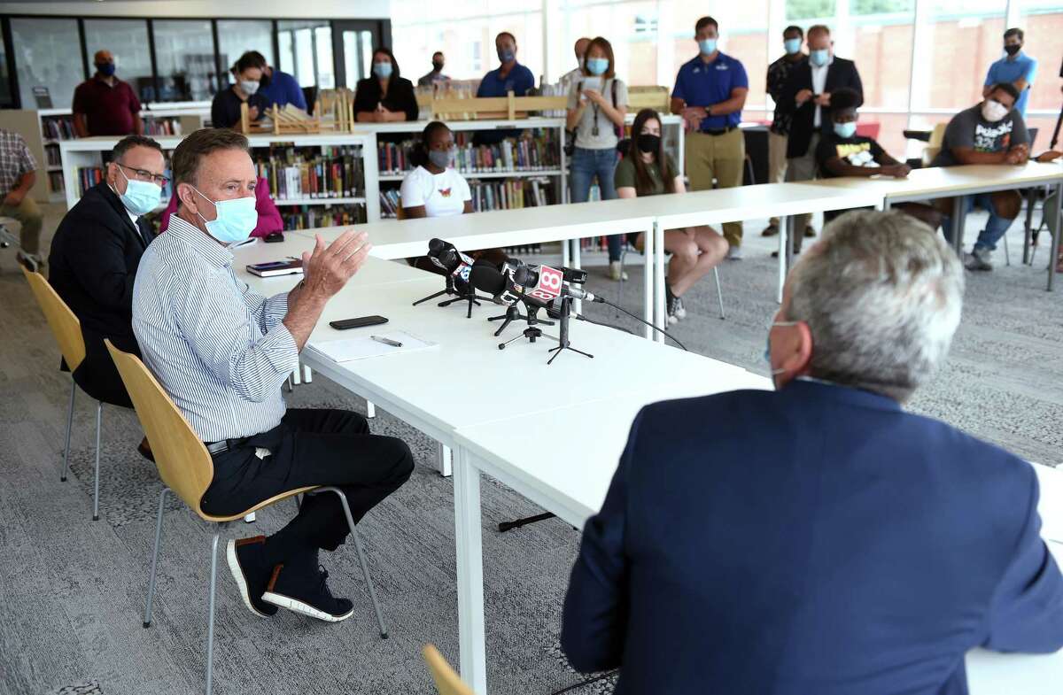 Seated from left, Connecticut Education Commissioner Miguel Cardona, Governor Ned Lamont and West Haven Superintendent of Schools Neil Cavallaro meet with students at West Haven High School on July 24, 2020.