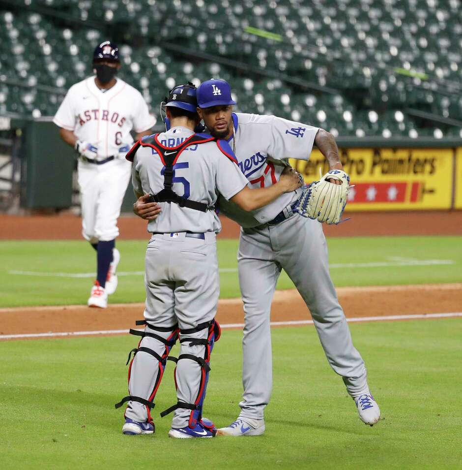Los Angeles Dodgers relief pitcher Dennis Santana (77) hugs catcher Austin Barnes (15) after the Dodgers beat the Astros 4-2 in the thirteenth inning of an MLB baseball game at Minute Maid Park, Wednesday, July 29, 2020, in Houston.