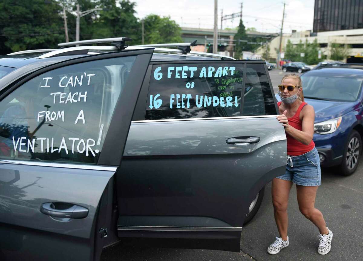 GHS math teacher Mary Zarra gets in her car for the teachers protest caravan in the Horseneck Lane parking lot in Greenwich, Conn. Thursday, July 30, 2020. The Connecticut Education Association and American Federation of Teachers Connecticut partnered with local union leaders to organize the event demanding the safety of students and teachers as well as state funding for reopening.