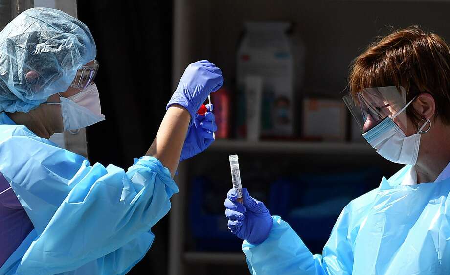 Medical workers at Kaiser Permanente French Campus test a patient for the novel coronavirus, COVID-19, at a drive-thru testing facility in San Francisco, California on March 12, 2020. - Between 70 to 150 million people in the United States could eventually be infected with the novel coronavirus, according to a projection shared with Congress, a lawmaker said March 12, 2020. (Photo by Josh Edelson / AFP) (Photo by JOSH EDELSON/AFP via Getty Images) Photo: JOSH EDELSON/AFP Via Getty Images