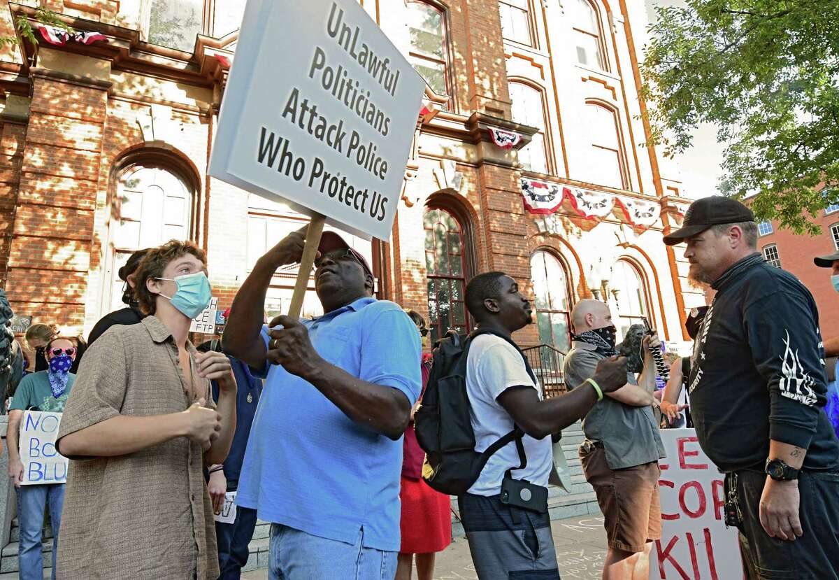People rallying for police, second from left, and man at right, engage in conversation with Black Lives Matter counter protesters, left, and second from right, in front of City Hall on Thursday, July 30, 2020 in Saratoga Springs, N.Y. (Lori Van Buren/Times Union)
