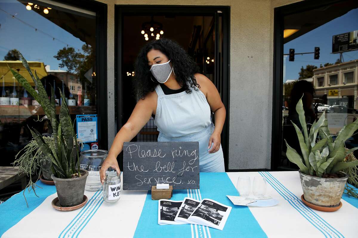 Jirka Jireh, a manager and sommelier, arranges the outdoor table at Ordinaire Wine Shop and Wine Bar, located at 3354 Grand Ave., on Friday, July 10, 2020, in Oakland, Calif. Jireh has begun organizing virtual wine classes for BIPOC across the country; the classes are free for all students, with the instructor donating time and wine companies donating all the wine.